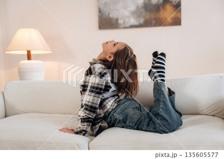 Fun on the sofa. Cute little girl is in the domestic room alone 135605577