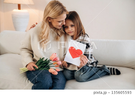 Expression of love at mother's day. Woman and her daughter are together in domestic room 135605593