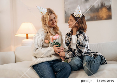 Happy birthday, mom, with gifts. Mother and daughter are together in domestic room 135605649