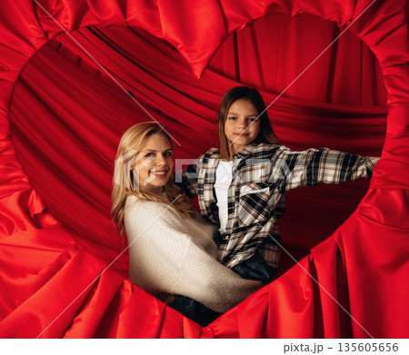 Mother's day, mom and daughter in heart shaped decorated room 135605656