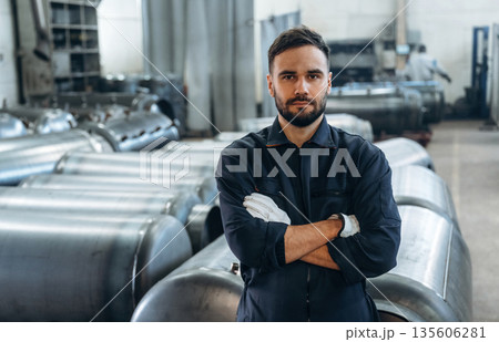 Front view, standing and posing. Man is working in the factory 135606281