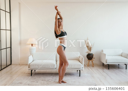 Showing the body. Young woman with slim body type is indoors 135606401