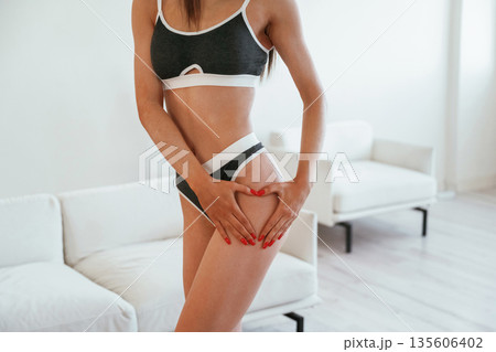 Love hands gesture, diet conception. Young woman with slim body type is indoors 135606402