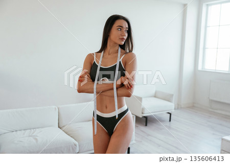 Weight loss conception. Young woman with slim body type is indoors Weight loss conception. Young woman with slim body type is indoors 135606413
