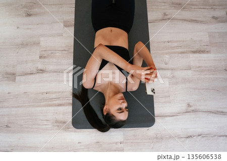 Hobby of yoga. Young woman with slim body type is indoors Hobby of yoga. Young woman with slim body type is indoors 135606538