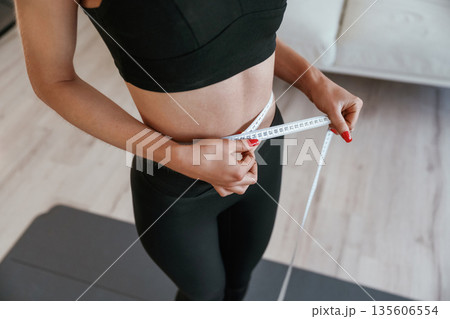 Conception of weight loss, diet. Young woman with slim body type is indoors 135606554