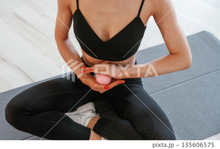 Detailed close up view, using massager roller on hands. Young woman with slim body type is indoors Detailed close up view, using massager roller on hands. Young woman with slim body type is indoors 135606575