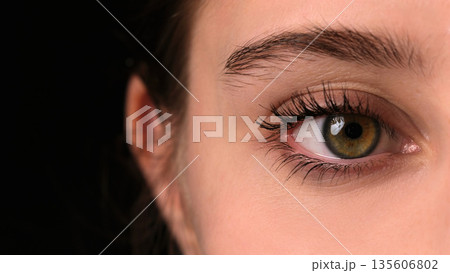 Girl Widely Opens Her Large Green Eye For A Close-Up View 135606802