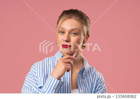 Charming Woman Doing Face Massage With Rose Quartz Stone Roller For Firmer 135608062