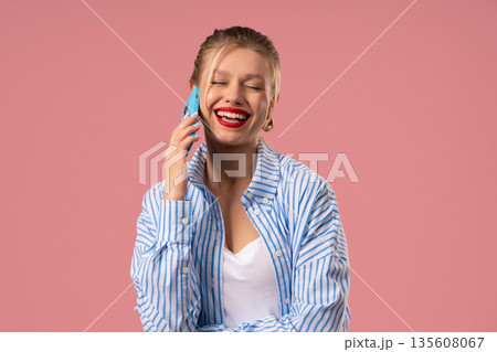 Positive Blonde Woman Talking On Smartphone, Showing Joy Of Mobile Connection Positive Blonde Woman Talking On Smartphone, Showing Joy Of Mobile Connection 135608067