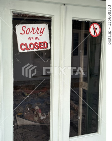 Closed sign displayed on shop door window with no smoking sign in background Closed sign displayed on shop door window with no smoking sign in background 135608353
