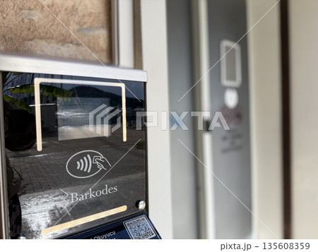 Electronic payment terminal near store entrance with blurred background Electronic payment terminal near store entrance with blurred background 135608359