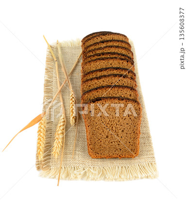 Sliced Rye Bread on Burlap Napkin with Wheat Ears Sliced Rye Bread on Burlap Napkin with Wheat Ears 135608377