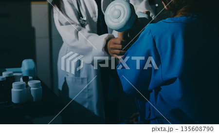 Physical therapist assisting a woman with dumbbell exercise Physical therapist assisting a woman with dumbbell exercise 135608790