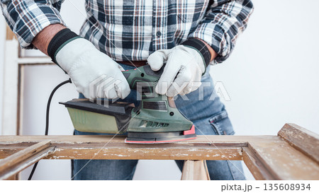 Carpenter at work, restoring an old wooden window. Carpentry. 135608934