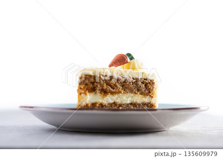 Carrot cake slice with cream cheese frosting on gray stone Carrot cake slice with cream cheese frosting on gray stone 135609979