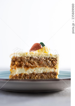 Carrot cake slice with cream cheese frosting on gray stone Carrot cake slice with cream cheese frosting on gray stone 135609980