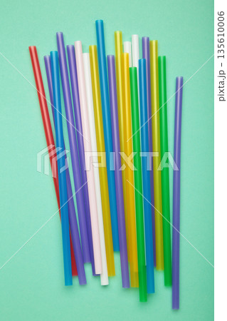 Set colorful plastic drinking straw on mint. Top view 135610006