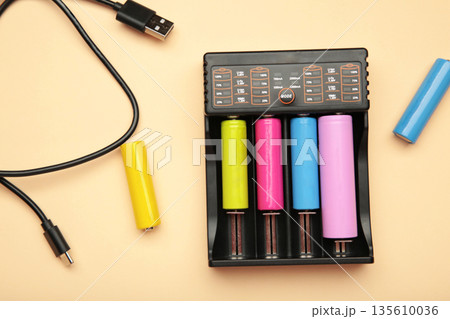 Rechargeable batteries in a battery charger. Four batteries in a charger. NI-MH and LI-MH battery. Rechargeable batteries in a battery charger. Four batteries in a charger. NI-MH and LI-MH battery. 135610036