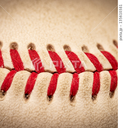 Macro close-up baseball ball with stiches and seam Macro close-up baseball ball with stiches and seam 135610381