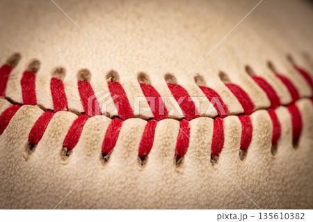 Macro close-up baseball ball with stiches and seam Macro close-up baseball ball with stiches and seam 135610382