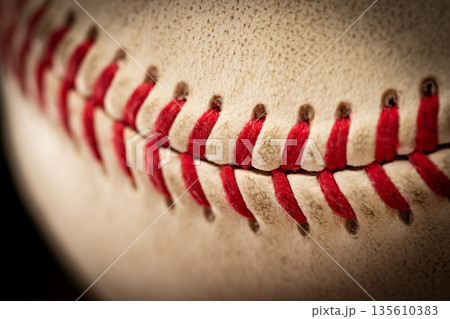 Macro close-up baseball ball with stiches and seam Macro close-up baseball ball with stiches and seam 135610383