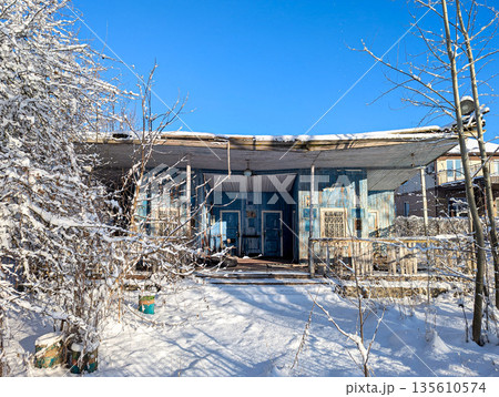 Old abandoned wooden house, boat station on a winter day 135610574