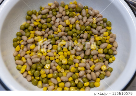 Mixed peas, beans, and corn in a bowl, top view, healthy food background Mixed peas, beans, and corn in a bowl, top view, healthy food background 135610579