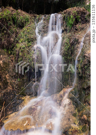 Blurred Water Cascading Over Green Mossy Rocks Blurred Water Cascading Over Green Mossy Rocks 135611136