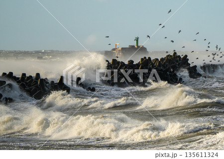 Powerful storm waves crash against breakwater near Liepaja harbor gate on the Baltic Sea coast 135611324