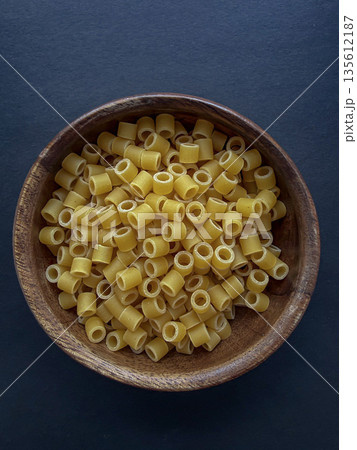 Dry Ditalini Pasta in Wooden Bowl on Dark Background Dry Ditalini Pasta in Wooden Bowl on Dark Background 135612187