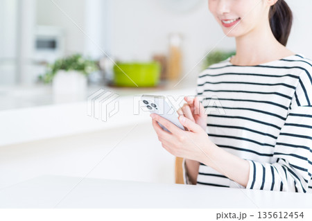 スマホを操作する若い女性（パーツモデル） 135612454