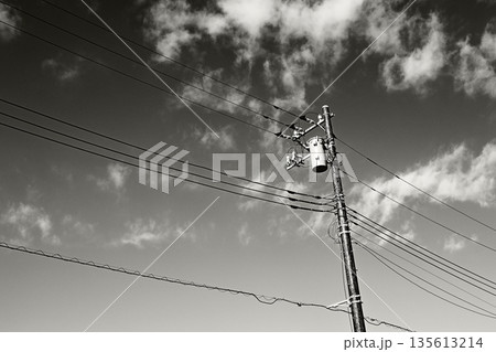 晴れた空と電信柱のモノクロ画像 135613214