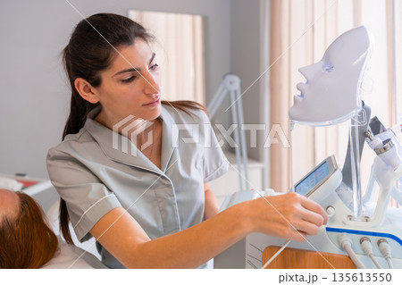 Cosmetologist preparing LED light therapy mask 135613550