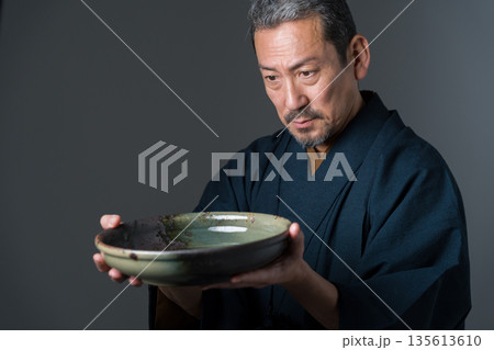 皿を持つ陶芸家の男性 135613610