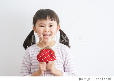 がま口財布を持つ子供（お金・お小遣い） 135613616
