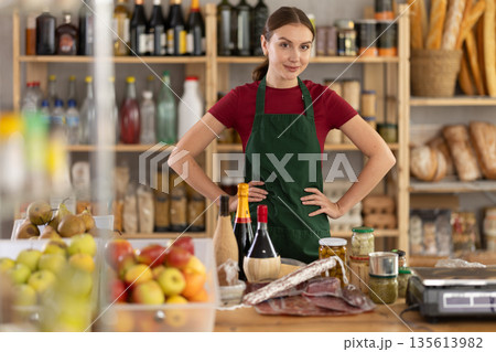 Smiling girl store clerk is preparing to meet customers Smiling girl store clerk is preparing to meet customers 135613982