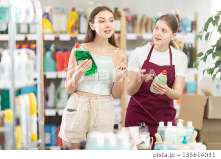 Sales girl offers woman choose dishwashing in household supermarket Sales girl offers woman choose dishwashing in household supermarket 135614031