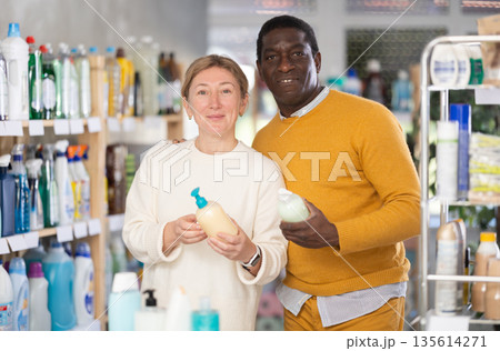 Before buying in household shop, African male customer with European wife choose liquid hand soap Before buying in household shop, African male customer with European wife choose liquid hand soap 135614271