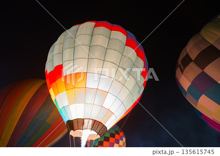 colorful hot air balloons glowing against dark night sky colorful hot air balloons glowing against dark night sky 135615745