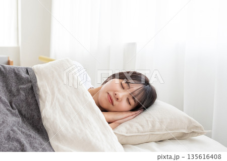 ベッドで眠る若い女性 135616408