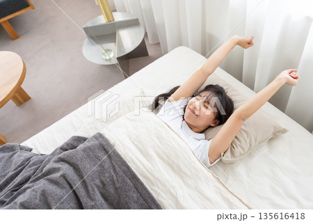 ベッドで伸びをする女性 ベッドで伸びをする女性 135616418