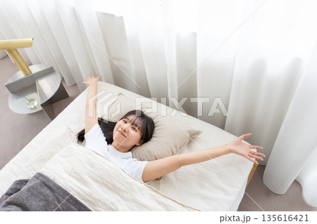 ベッドで伸びをする女性 ベッドで伸びをする女性 135616421