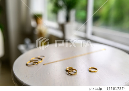 窓際で輝く金色の指輪 135617274