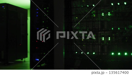 Rack-mounted servers pulsing LED lights in server room corridor, with switches and patch cables Rack-mounted servers pulsing LED lights in server room corridor, with switches and patch cables 135617400