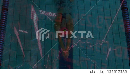 Swimmer wearing swimsuit and swim cap pushing off in competition pool, with lane ropes, graphics 135617586