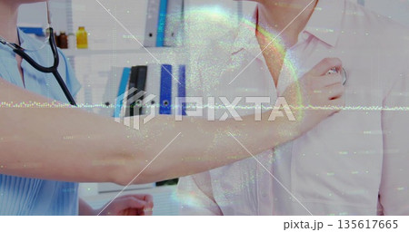 Listening medical professional in scrubs placing stethoscope on patient in exam room, with binders Listening medical professional in scrubs placing stethoscope on patient in exam room, with binders 135617665