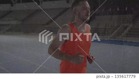Jogging runner wearing orange shirt and dark shorts on stadium track with empty seating, copy space Jogging runner wearing orange shirt and dark shorts on stadium track with empty seating, copy space 135617779