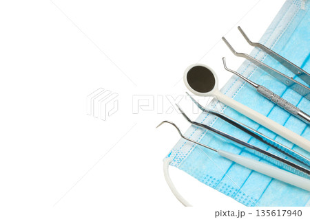 Dental tools on a blue face mask for treatment, isolated, PNG Dental tools on a blue face mask for treatment, isolated, PNG 135617940