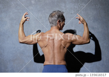ポーズをとる筋肉のあるシニアの男性 後ろ姿 ポーズをとる筋肉のあるシニアの男性 後ろ姿 135618317